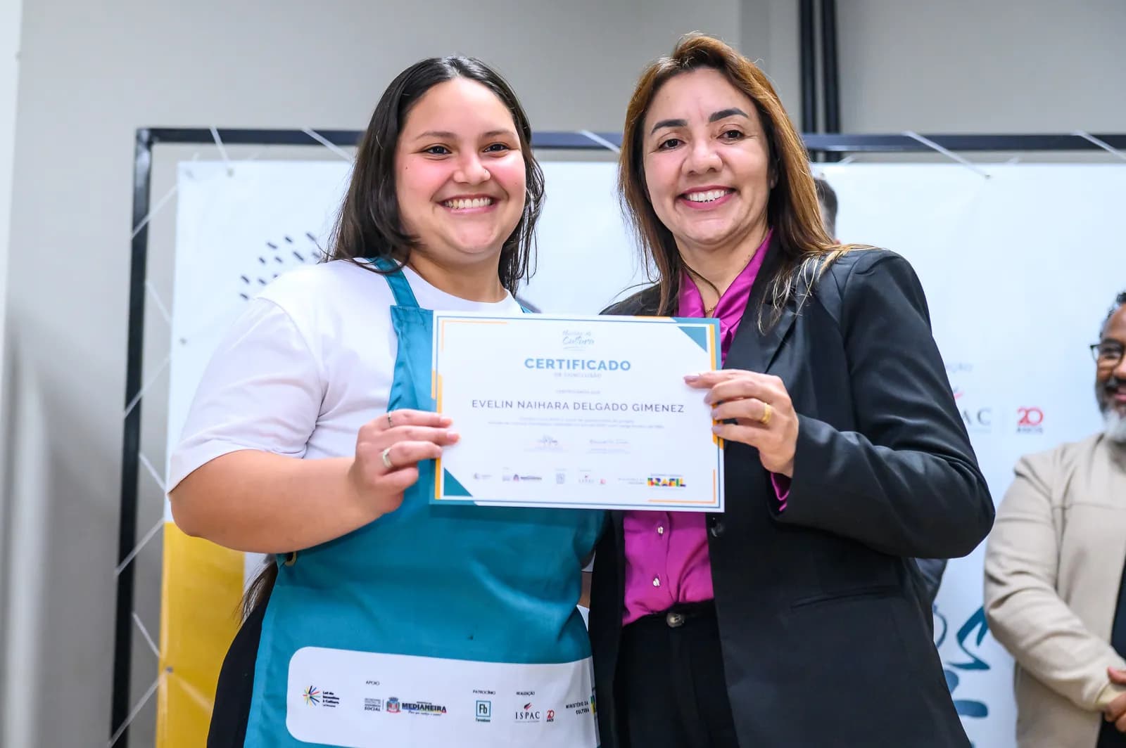 Aluna formada recebendo o certificado do curso de Gastronomia